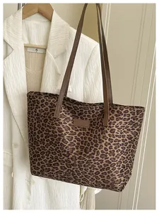 Dettaglio borsa shopper leopardata con spalline marroni e patch con logo moda