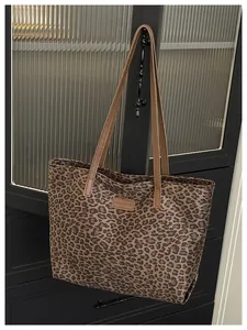 Dettaglio della borsa leopardata con patch logo in pelle e sottili spalline marroni