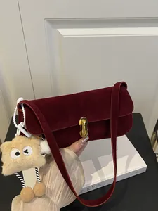 Vintage burgundy velvet underarm bag with gold lock and plush monster charm