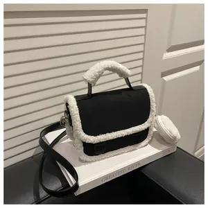 Detail view of suede saddle bag with plush shearling trim and mini round pouch pendant