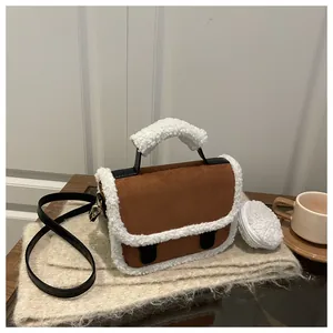 Detail view of brown suede saddle bag with white fleece trim and matching coin purse