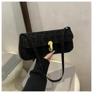 Detailansicht der schwarzen Wildledertasche mit Leopardenmuster und goldenem Metallschloss