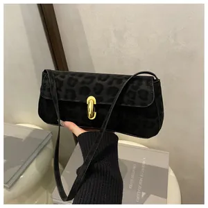 Detail der schwarzen Baguette-Tasche mit Leopardenmuster und goldenem Metallverschluss