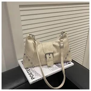 Macro detail of creamy faux leather texture and silver rivet studs on Y2K shoulder bag