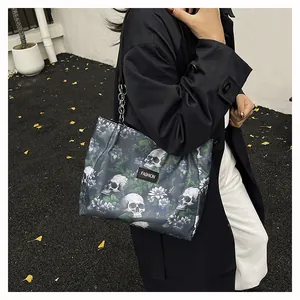 Detail of gothic tote bag with skull print and heavy silver metal chain strap
