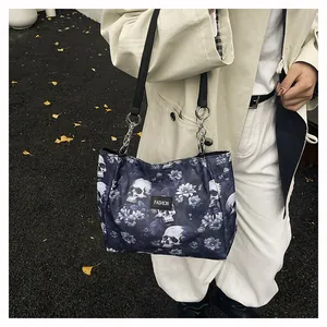 Detail of gothic skull print tote bag featuring metallic chain rings and fashion leather tag