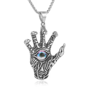 Macro view of gothic punk hand pendant with purple eyeball on a metal box chain