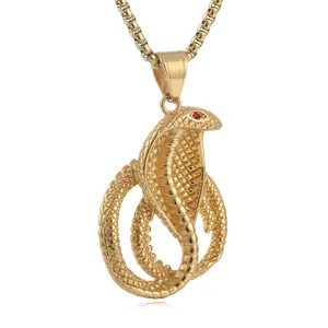 Dettaglio del ciondolo a cobra dorato con occhi di pietra rossa e texture a squame