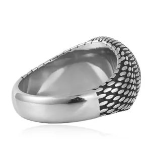 Macro detail of retro punk titanium steel ring with intricate scale texture and oxidized finish