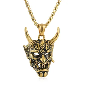Dettaglio ravvicinato del ciondolo maschera Hannya in acciaio titanio oro stile retrò