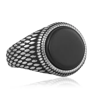 Macro detail of vintage punk ring with black stone inlay and fish scale texture