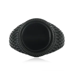 Macro shot of a vintage punk ring with black stone and scale-like engraved texture