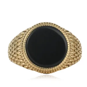 Detailed view of vintage gold steel ring with flat black stone and textured band