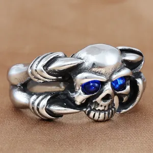 Vue détaillée d'une bague crâne vintage avec pierres bleues et finition acier punk