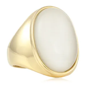 Vue macro d'une bague en acier doré avec une grande pierre précieuse ovale blanc laiteux