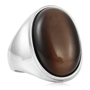 Détail macro d'une bague avec pierre ovale brune et anneau en acier poli