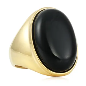 Vue détaillée d'une large bague dorée avec une grande pierre précieuse noire ovale polie