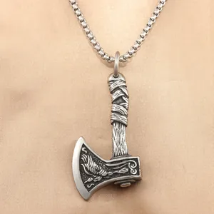 Detailed macro view of vintage stainless steel axe pendant with crow engraving detail