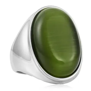 Gros plan d'une bague en acier avec une grande pierre verte ovale à effet œil de chat