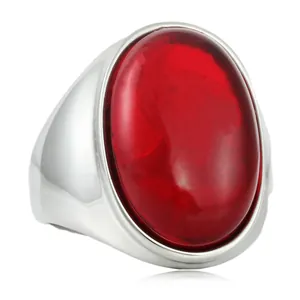 Détail macro d'une bague avec pierre rouge ovale et large bande en acier inoxydable