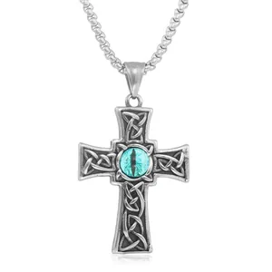 Macro shot of silver Celtic cross pendant with blue evil eye on a box chain