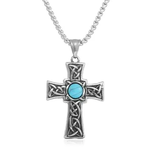 Macro detail of punk cross pendant with Celtic knotwork and green turquoise stone inlay