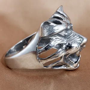 Punk style stainless steel wolf head ring with hollowed detail on brown silk background
