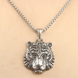 Detailed close-up of a punk style tiger head pendant on a vintage steel chain necklace