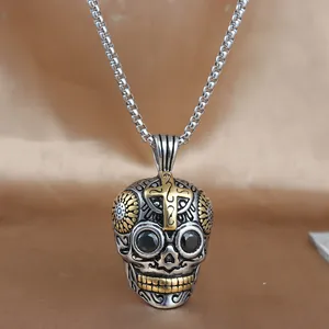 Detalle del colgante de calavera vintage con cruz dorada y piedra negra engastada