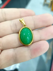 Détail d'un pendentif ovale en jade vert avec un cadre en acier titane plaqué or