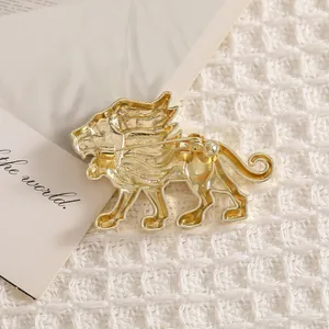 Broche de león vintage dorado vista posterior con pasador de metal sobre tela suave