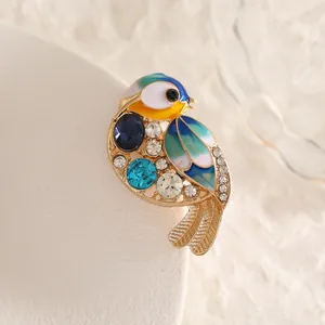 Exquisite bird brooch with enamel wings, blue rhinestones and sparkling crystals