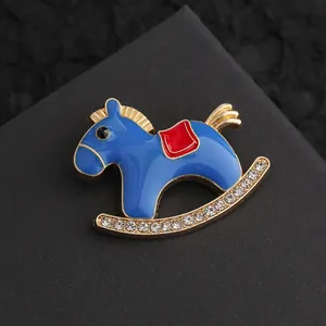 Macro shot of rocking horse brooch with blue enamel and sparkling white crystals