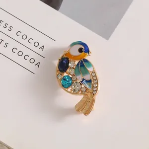 Exquisite bird brooch in gold alloy with colorful enamel and sparkling rhinestones