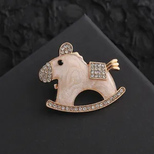 Macro detail of rocking horse brooch with pink enamel and sparkling crystal inlay