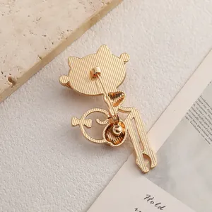 Broche gato dorado con piedra de ojo de gato y detalles traseros de metal texturizado
