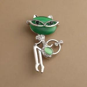 Lindo broche de gato con piedra ojo de gato verde y brillantes sobre metal plateado