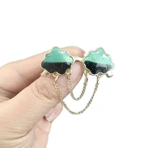 Cloud-shaped brooch with golden metal chain tassels in green and black enamel finish