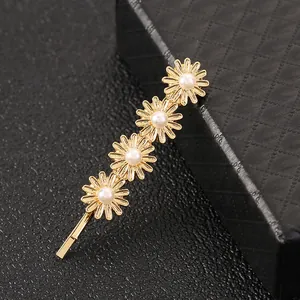 Elegant gold daisy hair clip with pearls and minimalist sunflower design for women
