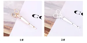 Detail von kreativen Haarklammern in Scherenform in Roségold und Silberoptik