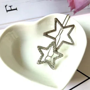 Détail de la barrette étoile argentée avec cristaux sur un plateau cœur blanc