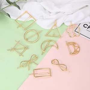 Detailed view of assorted gold geometric metal hair clips on a stylish decorative background