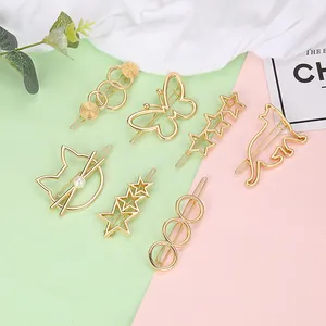 Gold metal hair clips set with cat, butterfly, and star shapes on a pastel background