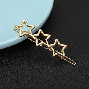 Close-up of golden alloy hair clip featuring three hollow star-shaped geometric elements