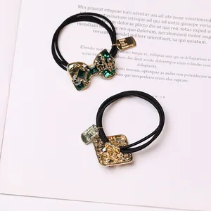 Elegantes Haargummi-Set mit Schleife, Kristallen und smaragdgrünen Strasssteinen in Schwarz