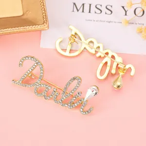 Macro detail of Darling script brooch with rhinestones on a decorative background