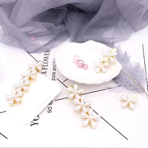 Nahaufnahme von vierteiligem Perlenblumen-Haarspangen-Set mit goldener Legierung