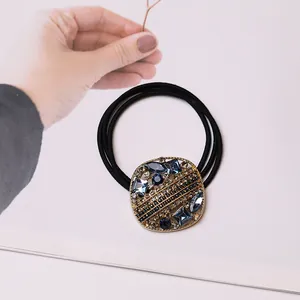 Detail des Vintage-Haargummis mit blauen Kristallen und Strass auf schwarzen Bändern