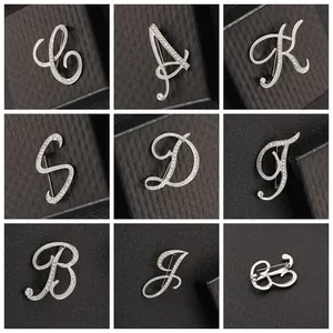 Detalle de broches de letras plateadas con diseño elegante e incrustación de cristal