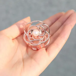Pince à cheveux fleur minimaliste en métal or rose avec perle tenue à la main